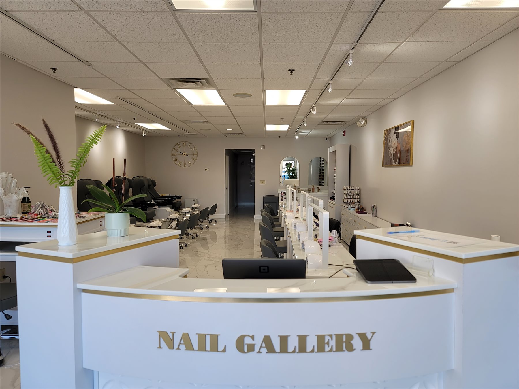 Nail Gallery reception desk with gold lettering and pedicure chairs, East Lyme nail salon interior