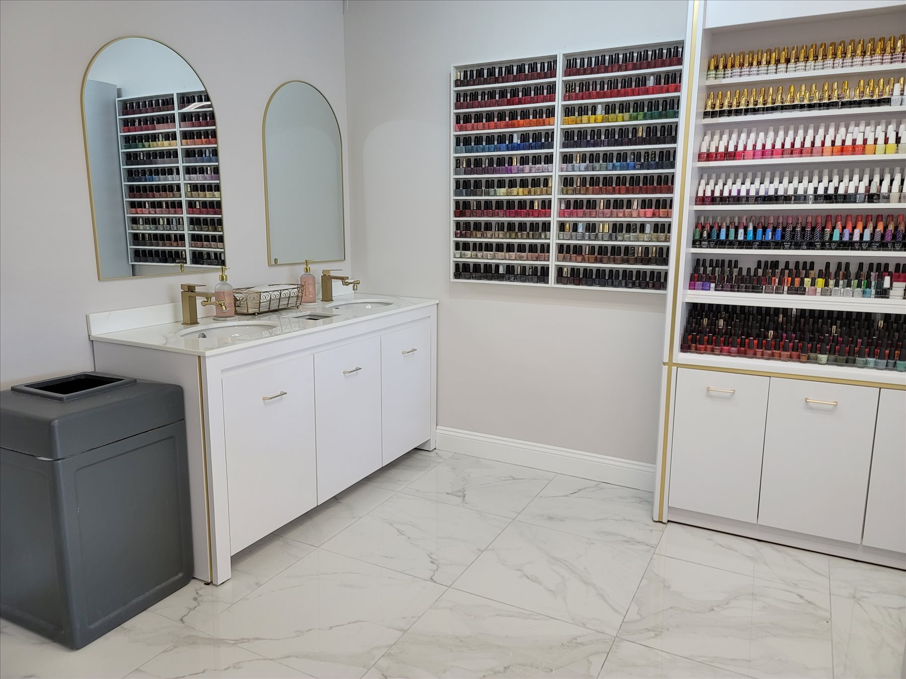 Nail polish color wall at Nail Gallery, the Flanders Plaza nail salon in East Lyme, CT, beside arched gold mirrors